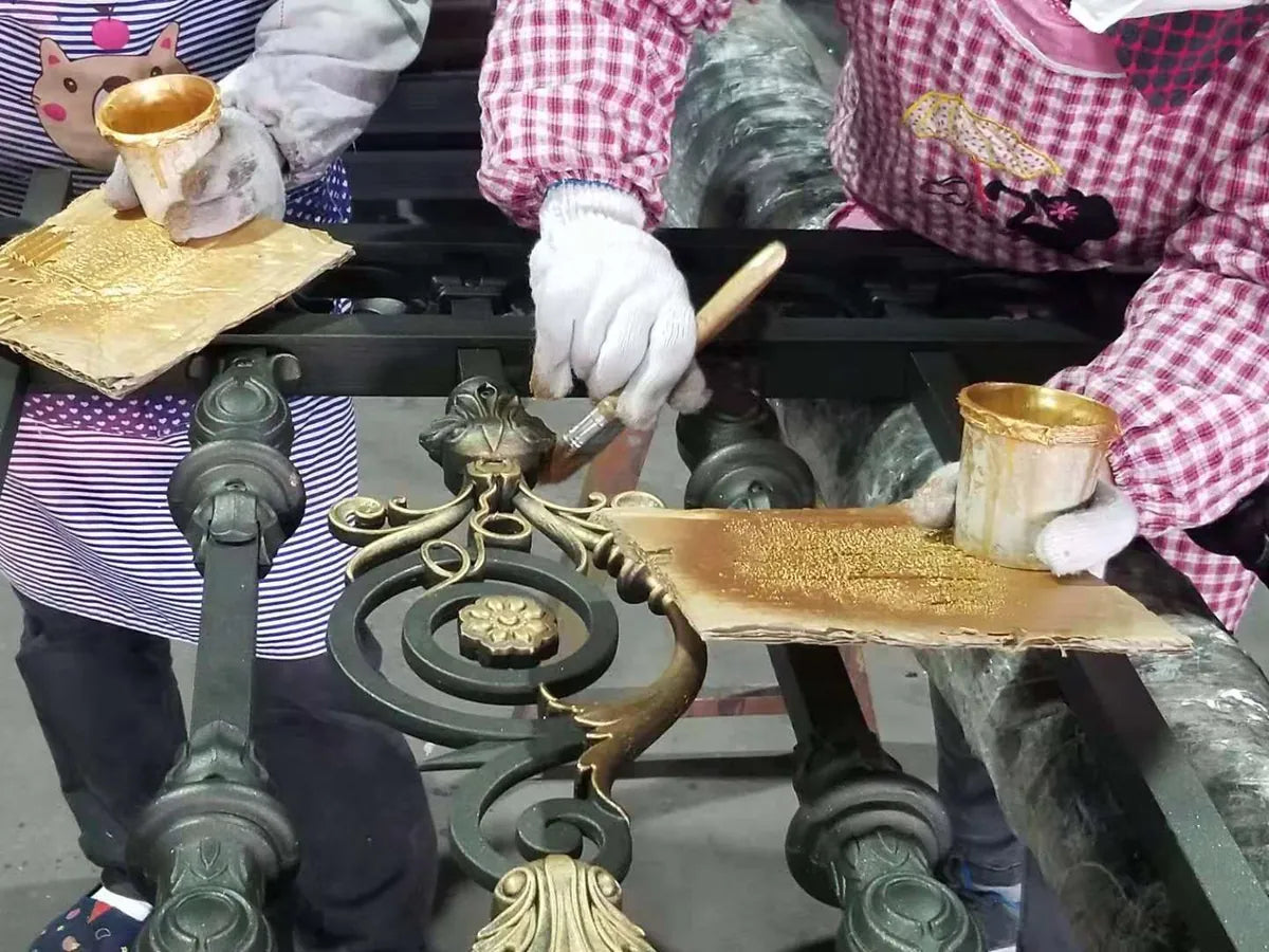 A brush picking out the raised relief of a cast aluminium ornament in gold
