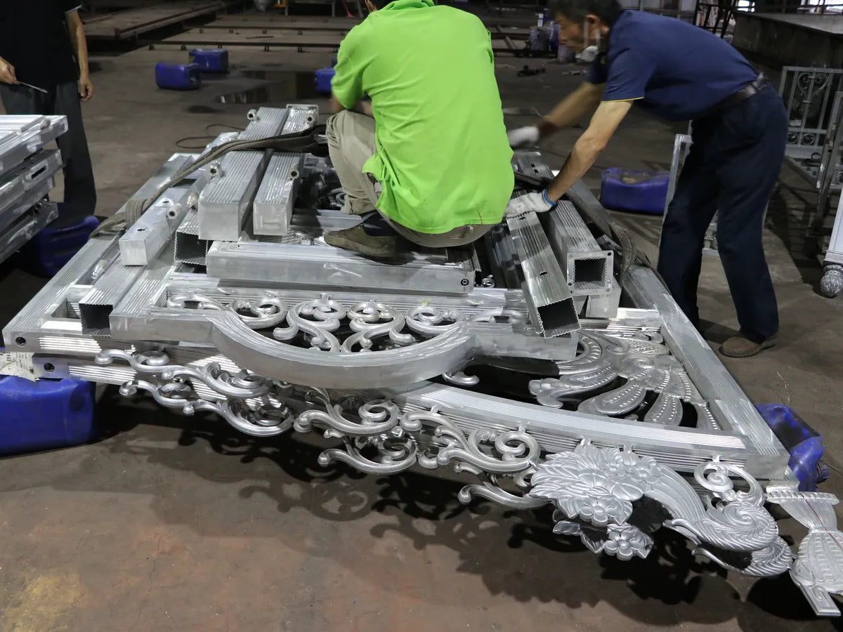 Two workers dressing a large cast panel on the floor